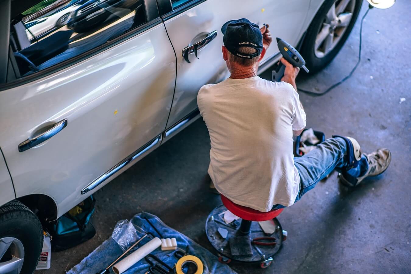 Image of a man repairing a car for a web design